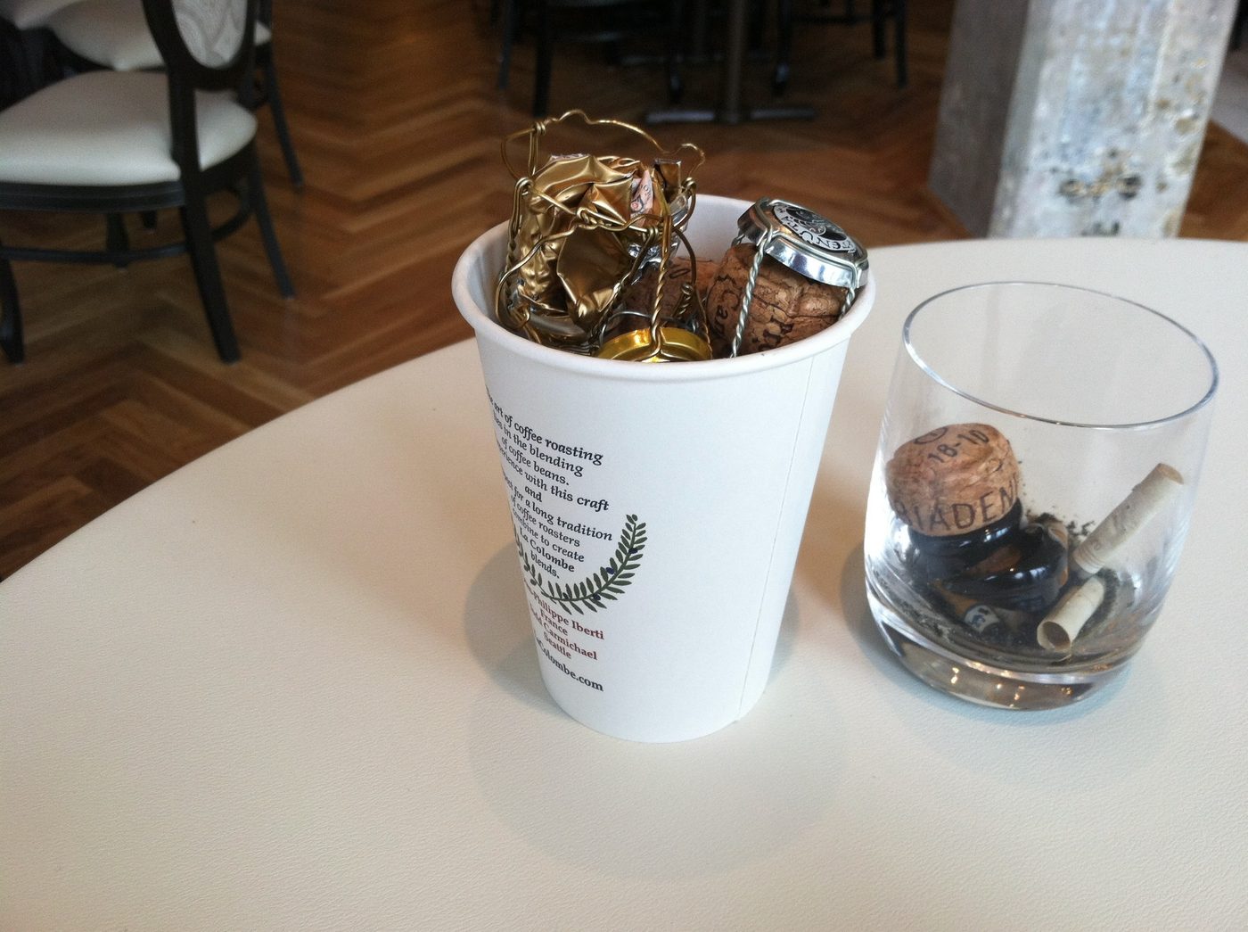 The morning after opening night at Nellcôte, Chicago, February 2012. A La Colombe coffee cup holds spent champagne cages and wine corks on the table the owners left behind.